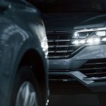 Powerful headlights. Particle view of modern luxury cars parked indoors at daytime.